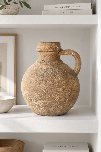 Aged brown decorative jug styled on a white built-in shelf.
