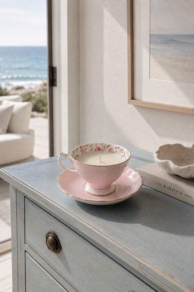 Pink rose china teacup and saucer soy candle styled on a coastal console