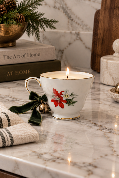 Vintage poinsettia porcelain teacup candle with green velvet ribbon and brass bell