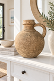 Aged brown decorative jug styled on a white coastal entryway console.