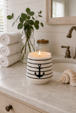 Black stripe anchor ceramic soy candle in a coastal bathroom setting