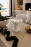 Beaded milk glass pedestal three-wick soy candle styled in a refined coastal interior