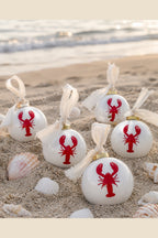 White ceramic ball ornament with red lobster motif and ivory fabric tie