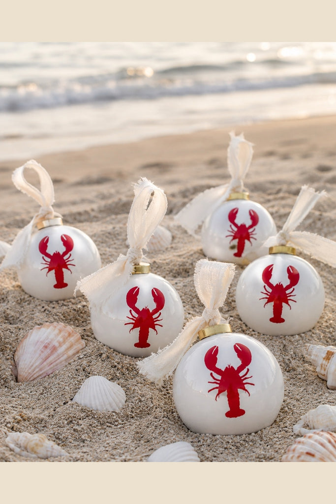 White ceramic ball ornament with red lobster motif and ivory fabric tie