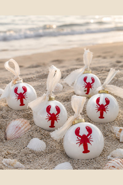 White ceramic ball ornament with red lobster motif and ivory fabric tie
