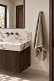 Smoked brown striped terry bath towel in a modern marble bathroom