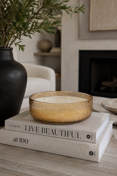 Pearlescent blush embossed glass soy candle styled in a modern living room