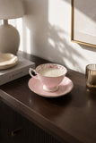 Pink rose china teacup and saucer soy candle styled on a dark wood console