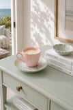 Pink teacup and floral saucer soy candle styled in a coastal interior