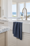 Stone-washed soft indigo dish towel staged in a modern beach house kitchen
