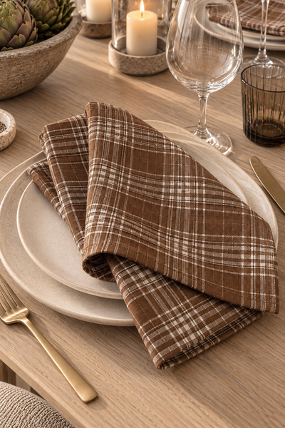 Tobacco plaid dinner napkins styled on a light washed oak table